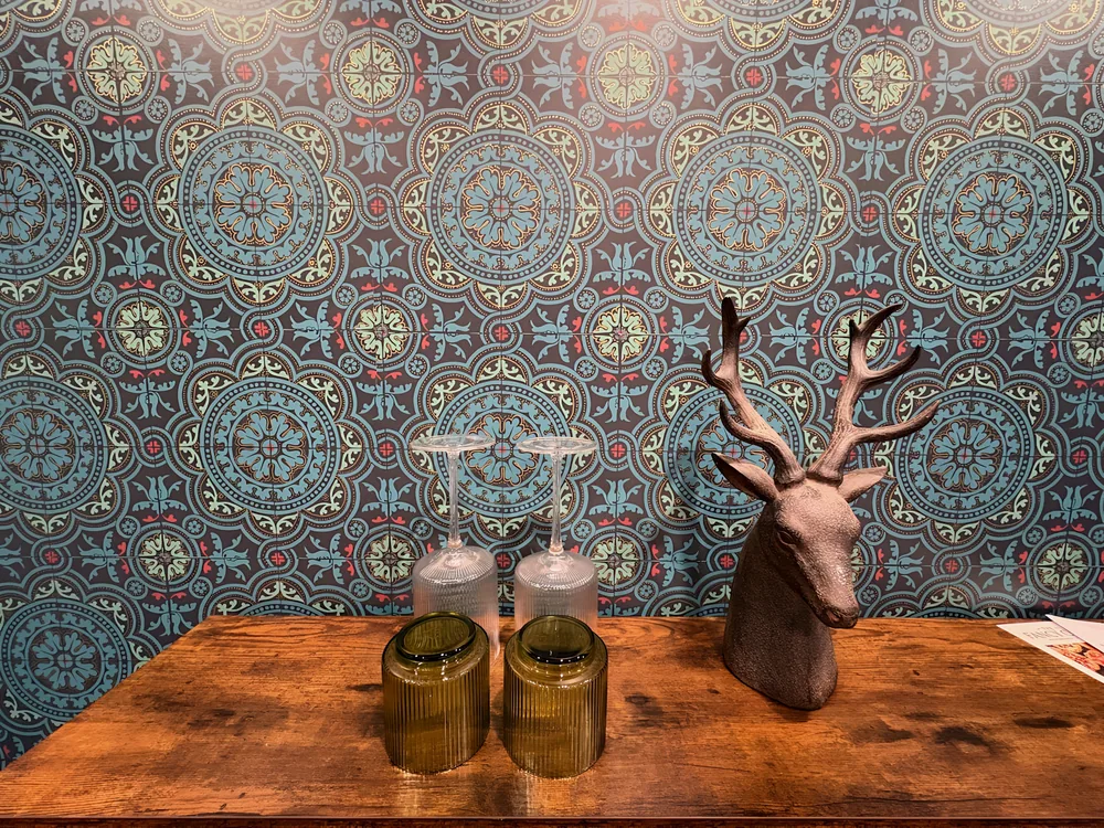 The blue medallion wallpaper and golden decor in the real room